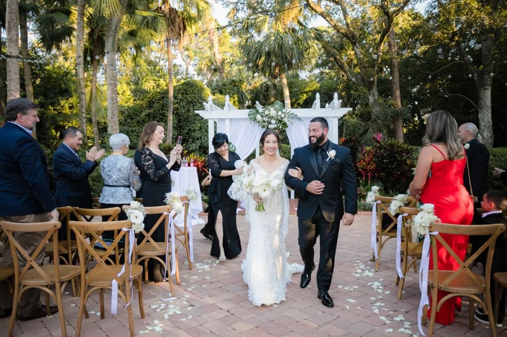 Happy Newlyweds Walking from the Garden Villa Altar at All-Inclusive Wedding Orlando