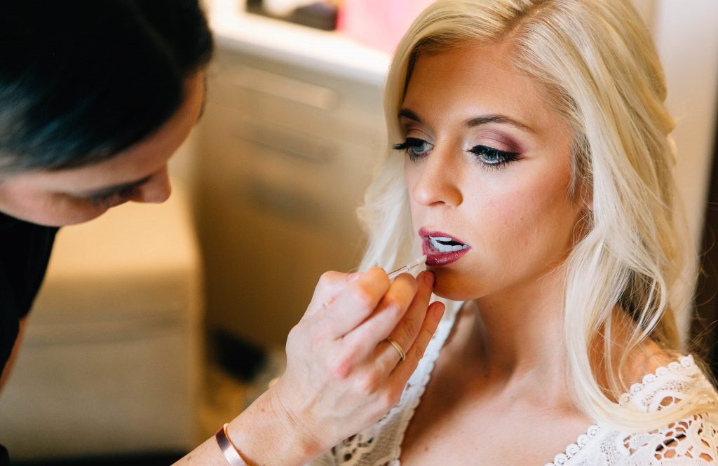 Makeup Artist Applying Lip Gloss on Bride