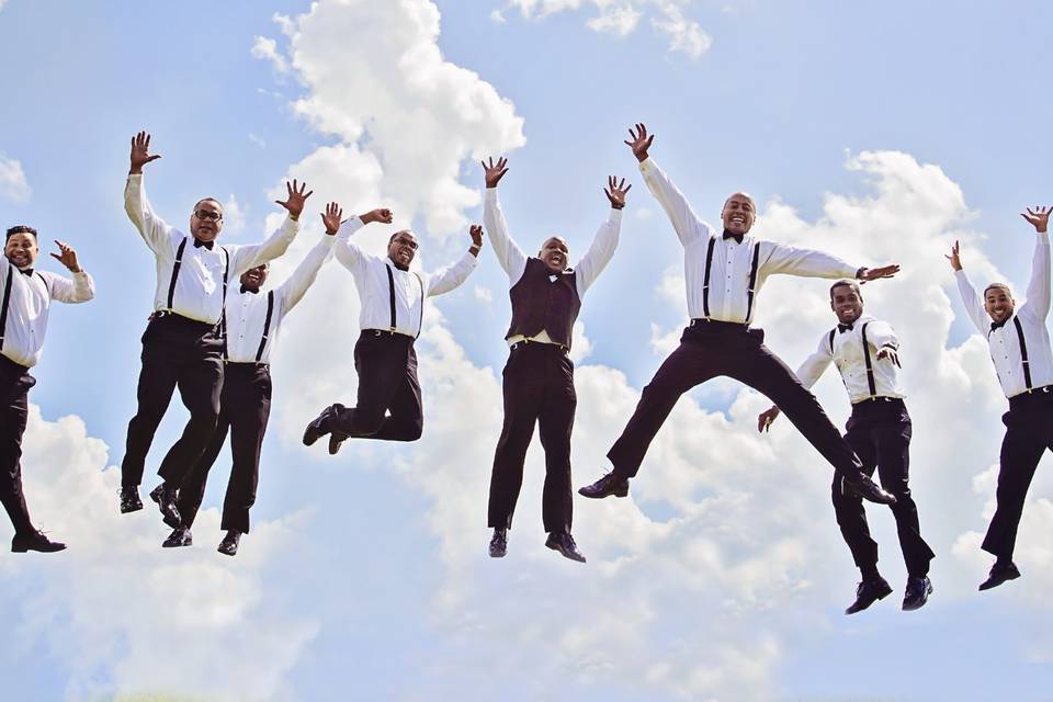 An exhilarating and energetic photo taken by DeMarco Films, showcasing the groom and his groomsmen in mid-air as they joyfully fall from the sky. Their beaming smiles and carefree expressions reflect the excitement and camaraderie of this unforgettable moment