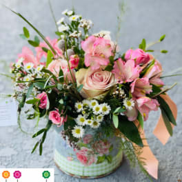 A delicate blend of pink and white roses in a charming light blue vase, expertly arranged by the Flower Studio.