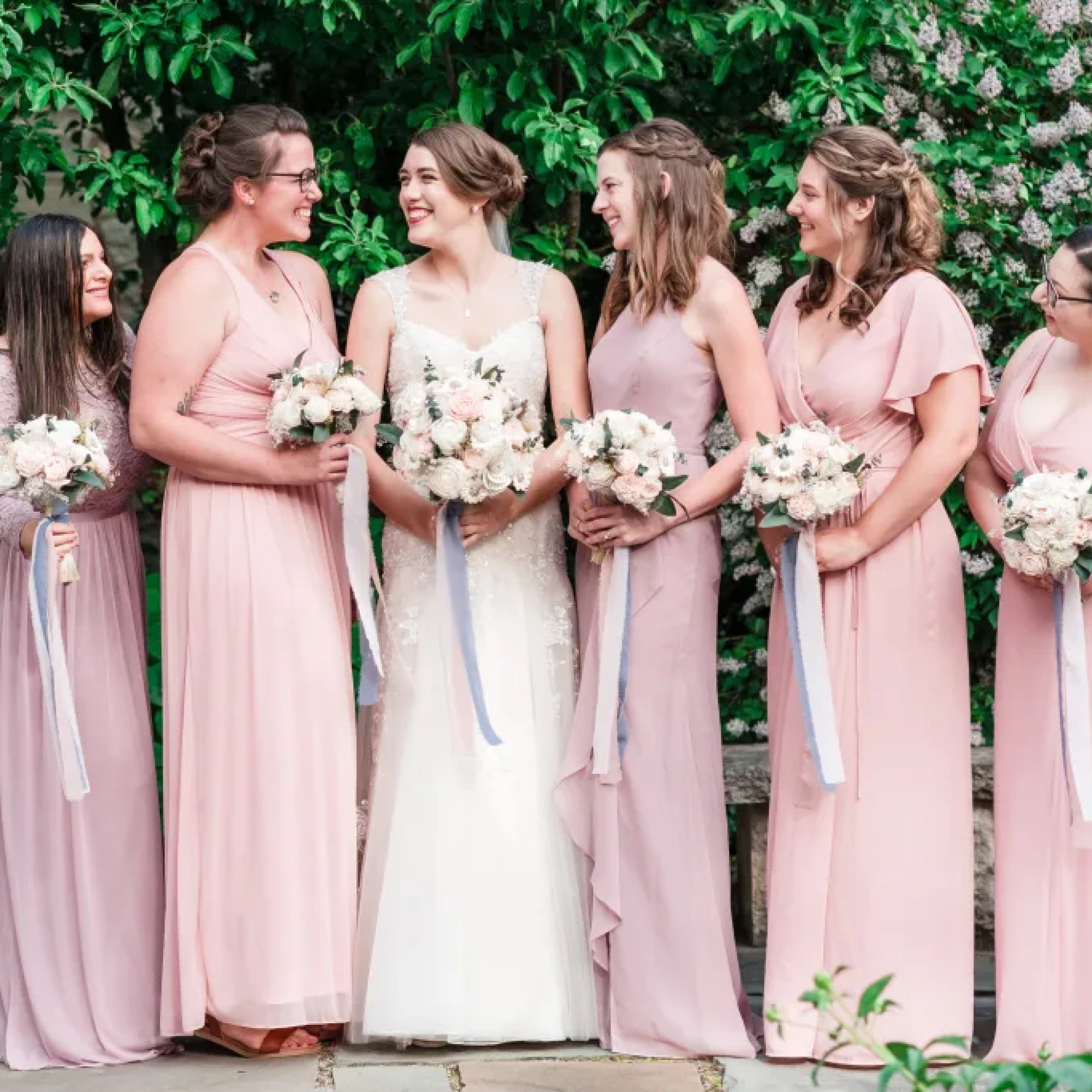 Radiant bride sharing a heartwarming moment filled with laughter and smiles alongside her beautiful bridesmaids, creating unforgettable memories at All Inclusive Weddings Orlando