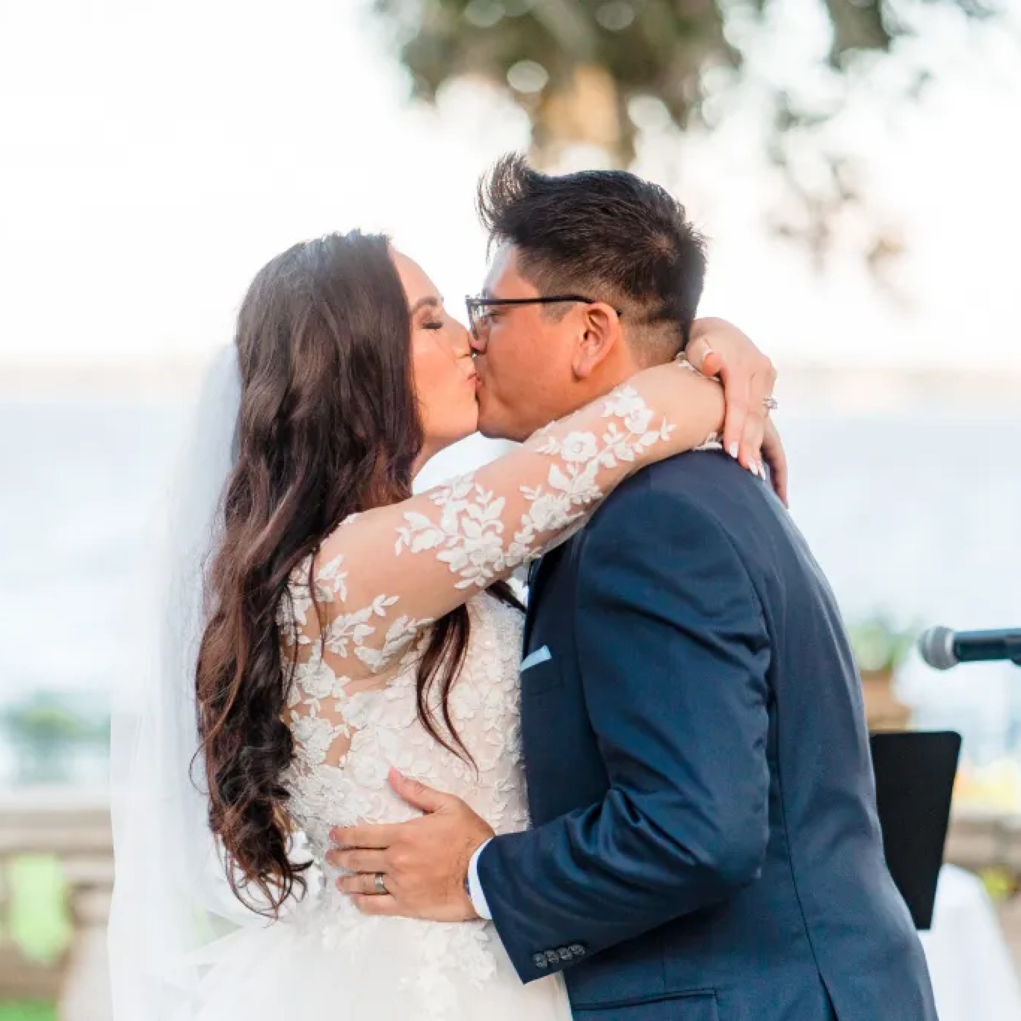 Jerzy Nieves Photography - Stylishly dressed bride and groom sharing a passionate kiss, showcasing their love and fashion-forward elegance at All Inclusive Weddings Orlando