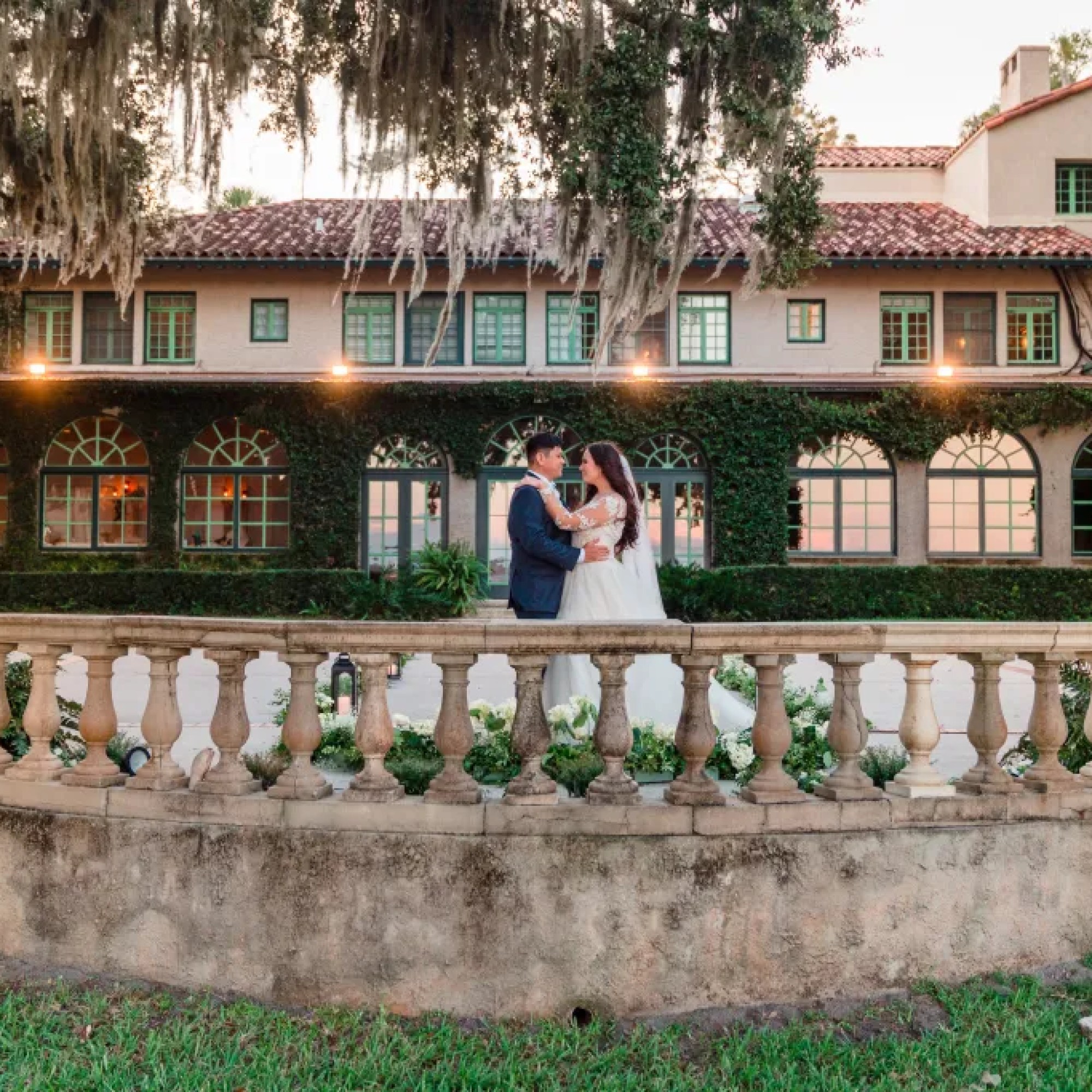 Jerzy Nieves Photography - Romantic shot of the bride and groom embracing each other under a beautifully adorned tree, capturing the essence of their love and intimacy at All Inclusive Weddings Orlando