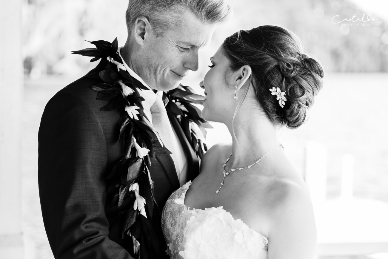 In this captivating black and white photograph by Castaldo Studio, a groom and his radiant bride lock eyes with joyful expressions. The absence of color accentuates the raw emotion and genuine happiness in their gaze. The timeless black and white aesthetic adds a touch of nostalgia and highlights the deep connection between the couple. It's a timeless moment of pure love and joy captured beautifully on their wedding day