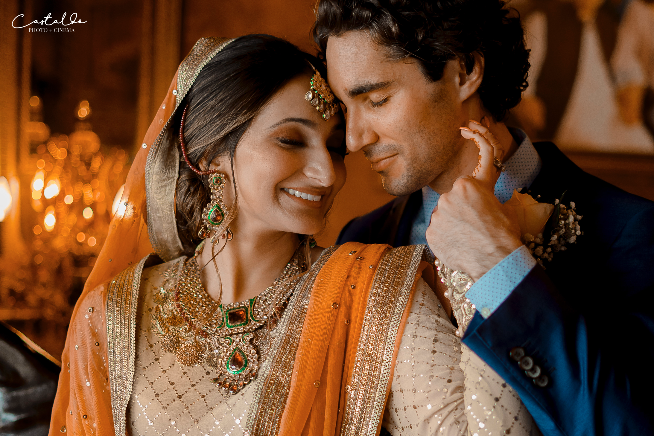 In this enchanting image captured by Castaldo Studio, the bride and her husband, dressed in traditional Indian wedding attire, share an intimate and heartfelt embrace. With their eyes closed, foreheads touching, and hands clasped together, they exude a profound sense of love and connection. The composition beautifully showcases the elegance and romance of their special bond, symbolizing the beginning of a lifelong journey together.