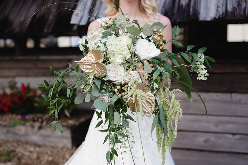 The Flower Studio: Breathtaking bridal bouquet featuring white roses and intricate gold embellishments, showcasing elegance and beauty.