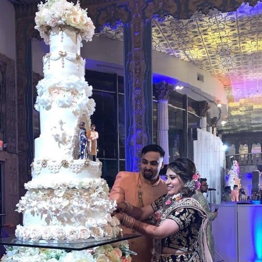 Bride and Groom Cutting Elaborately Decorated Wedding Cake