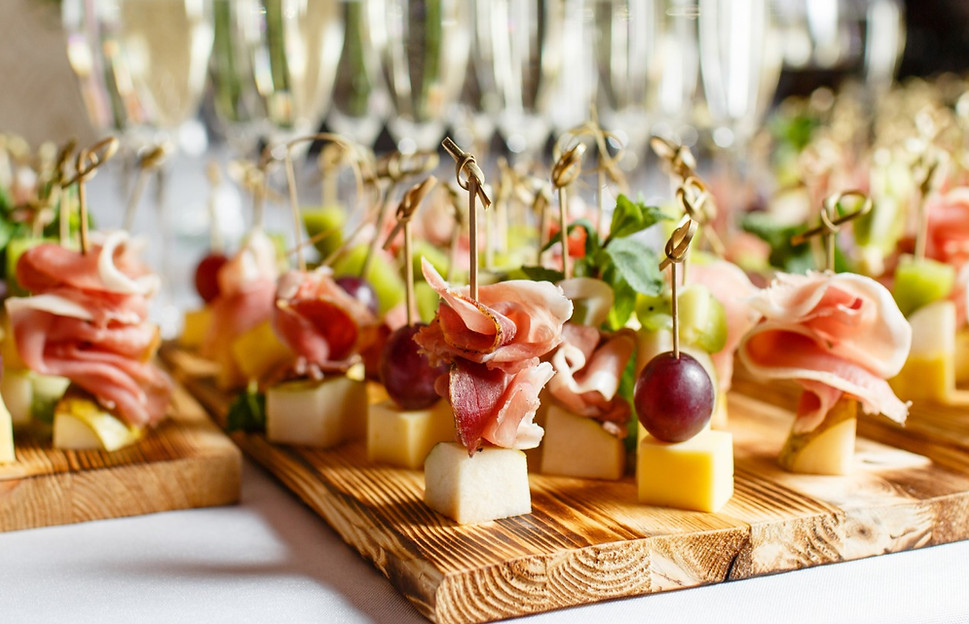 Blurred Crystal Glasses in Background, Cutting Boards with Assorted Appetizers in Foreground