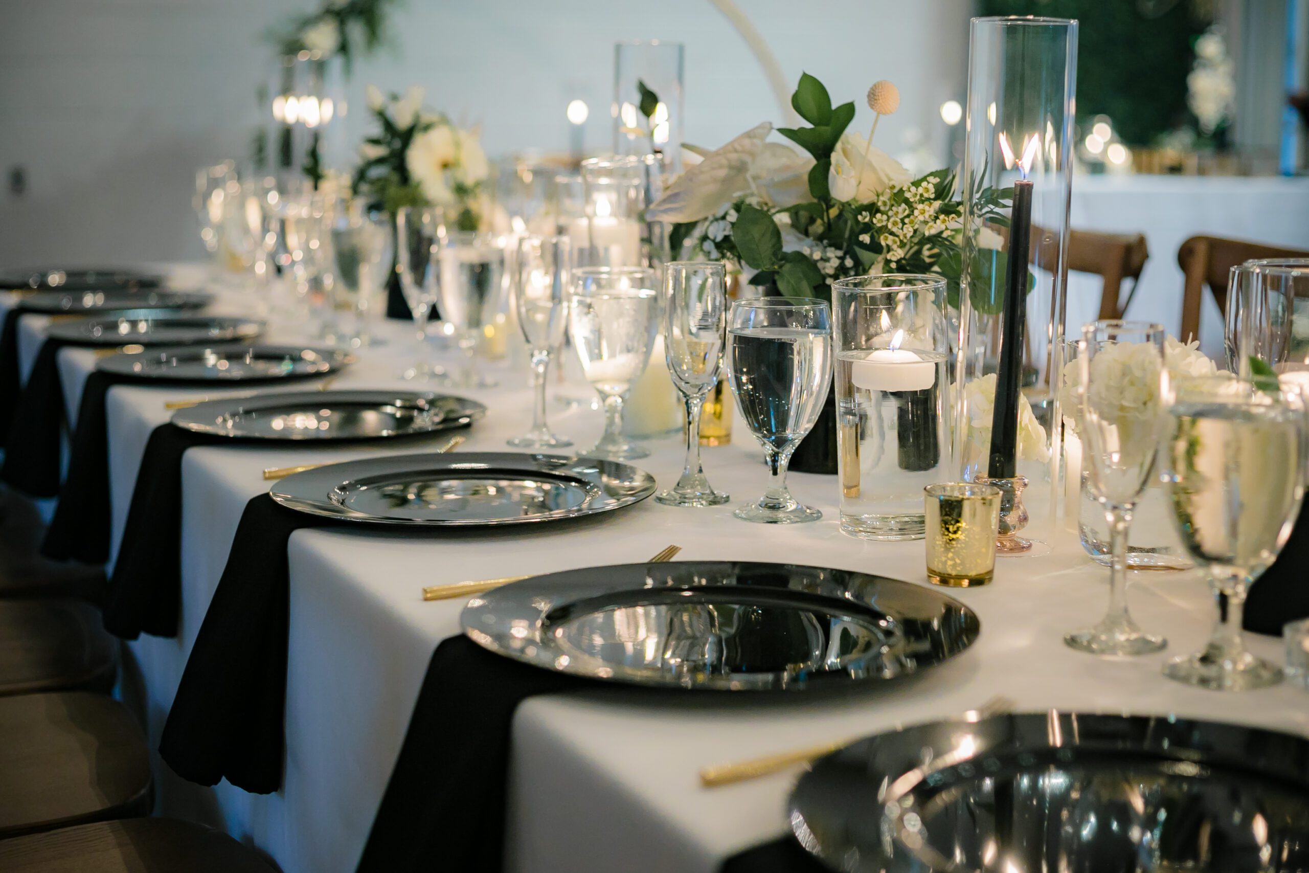 Elegant table setting with black plates and gold silverware, exuding sophistication and class at All Inclusive Weddings Orlando.